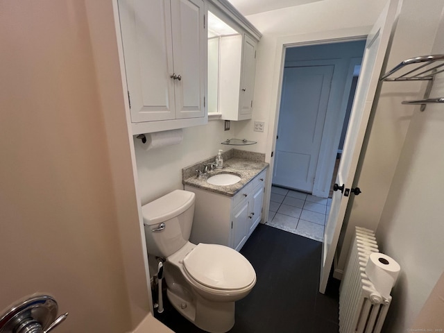 337 Charles St, Torrington, CT 06790 - bathroom with radiator heating unit, toilet, vanity, and tile patterned floors