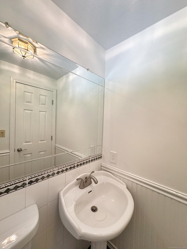17 Currituck Rd, Newtown, CT 06470 - half bath with a sink, a wainscoted wall, and toilet