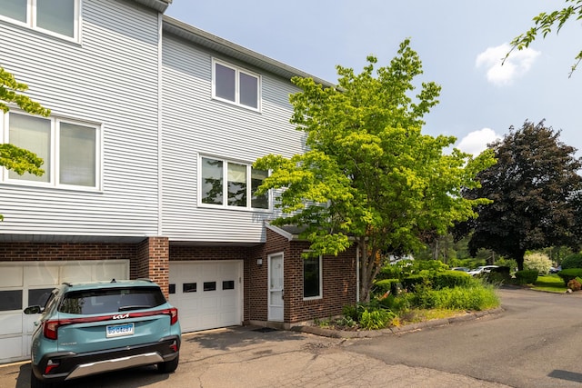 30 Sheila Ct Apt 31, Bristol, CT 06010 - view of front of house featuring a garage, driveway, and brick siding