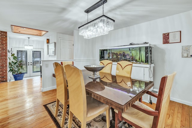 575 W Todd St, Hamden, CT 06518 - dining room featuring light wood finished floors, french doors, a chandelier, and baseboards