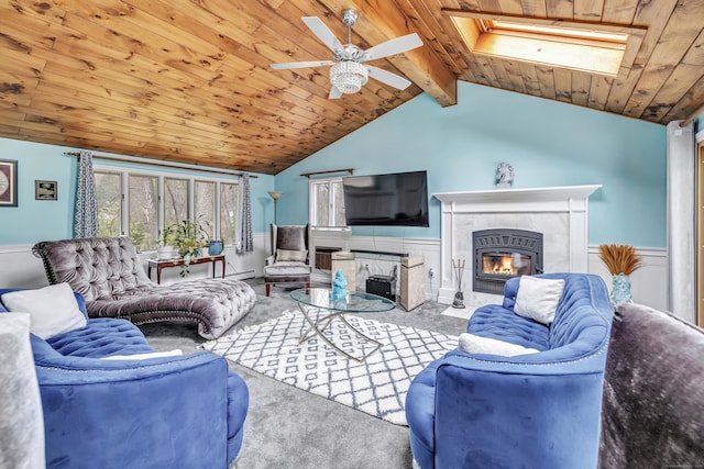 575 W Todd St, Hamden, CT 06518 - carpeted living room featuring wooden ceiling, a skylight, a fireplace, a wainscoted wall, and ceiling fan