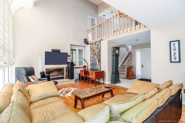 230 New Canaan Ave Apt 2, Norwalk, CT 06850 - living room featuring wood finished floors, a high ceiling, stairway, a glass covered fireplace, and baseboards