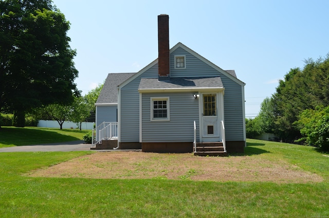 55 Cloudland Rd, North Haven, CT 06473 - rear view of house featuring entry steps, roof with shingles, a lawn, and a chimney