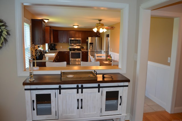 55 Cloudland Rd, North Haven, CT 06473 - kitchen featuring stainless steel appliances, a wainscoted wall, ceiling fan, light countertops, and dark brown cabinets