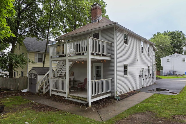 72 Beech St, Bristol, CT 06010 - rear view of house featuring a wooden deck, a storage shed, a chimney, and stairway