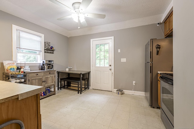 72 Beech St, Bristol, CT 06010 - kitchen with electric stove, healthy amount of natural light, ceiling fan, light countertops, and a textured ceiling