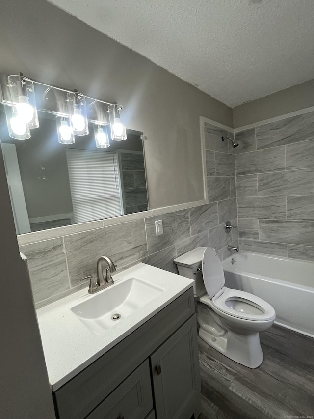 20 Cossett St, Waterbury, CT 06704 - bathroom with tile walls, vanity, wood finished floors, a textured ceiling, and bathtub / shower combination