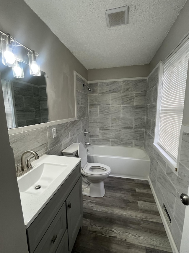 20 Cossett St, Waterbury, CT 06704 - full bath with tile walls, vanity, a textured ceiling, wood finished floors, and shower / bath combination