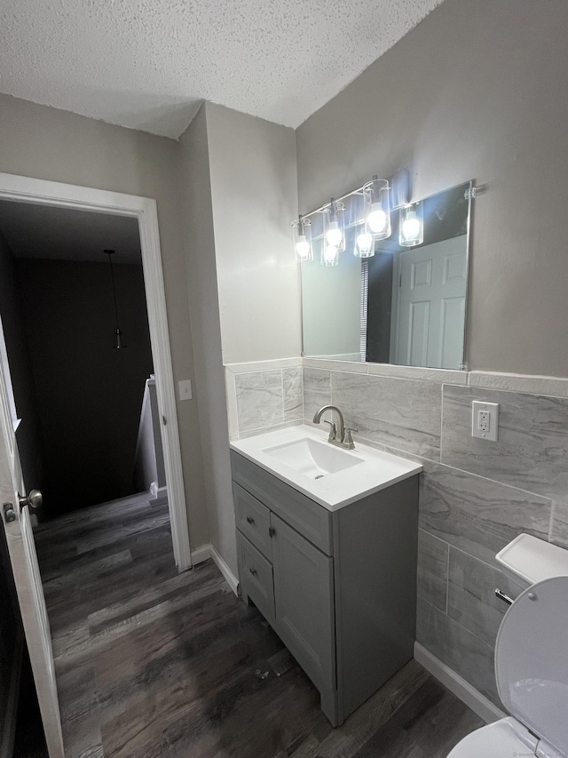 20 Cossett St, Waterbury, CT 06704 - bathroom with tile walls, wood finished floors, vanity, a textured ceiling, and wainscoting