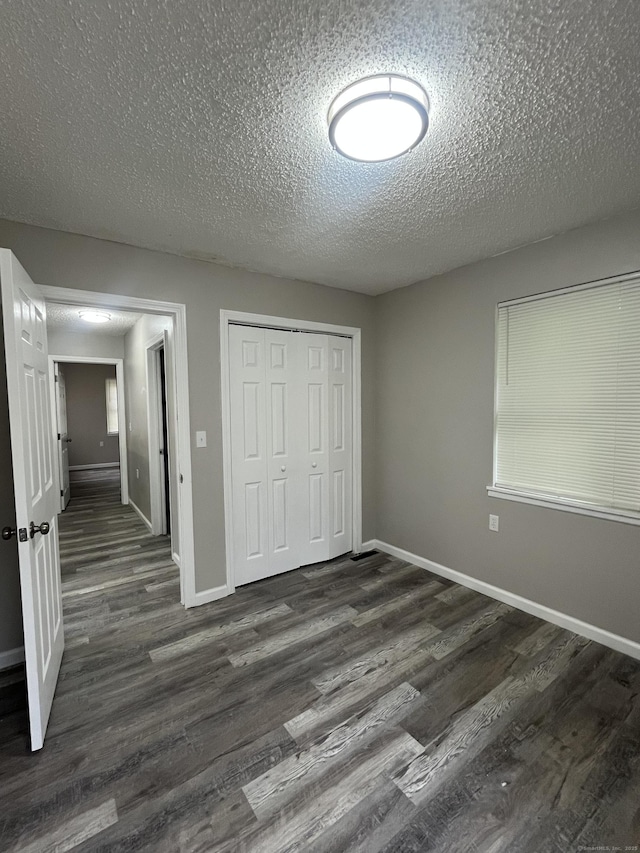 20 Cossett St, Waterbury, CT 06704 - unfurnished bedroom with dark wood-type flooring, a textured ceiling, and a closet