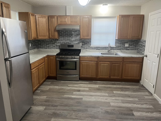 20 Cossett St, Waterbury, CT 06704 - kitchen with stainless steel appliances, under cabinet range hood, wood finished floors, tasteful backsplash, and light countertops