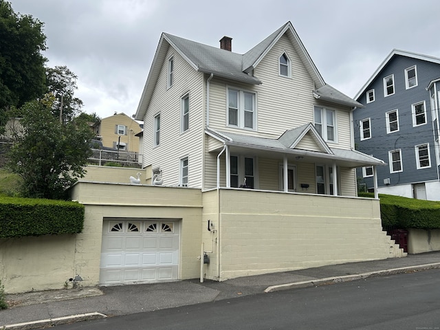 48 Anderson St, Naugatuck, CT 06770 - view of front of property featuring a garage, a chimney, driveway, and a porch