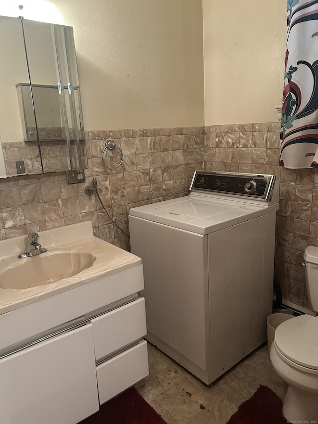 48 Anderson St, Naugatuck, CT 06770 - bathroom featuring washer / dryer, tile walls, toilet, vanity, and a wainscoted wall