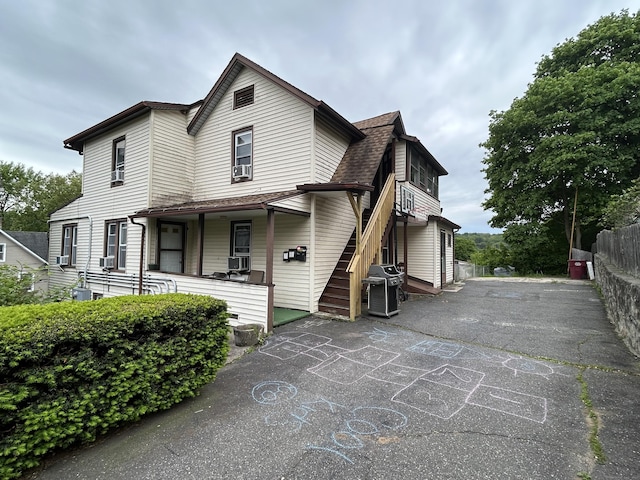 48 Anderson St, Naugatuck, CT 06770 - view of front of house with roof with shingles, cooling unit, driveway, and a porch