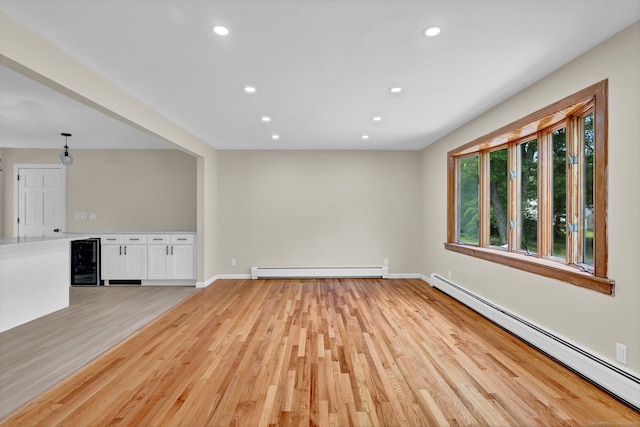 890 Copper Hill Rd, Suffield, CT 06093 - unfurnished living room featuring baseboard heating, beverage cooler, a baseboard radiator, light wood-type flooring, and recessed lighting
