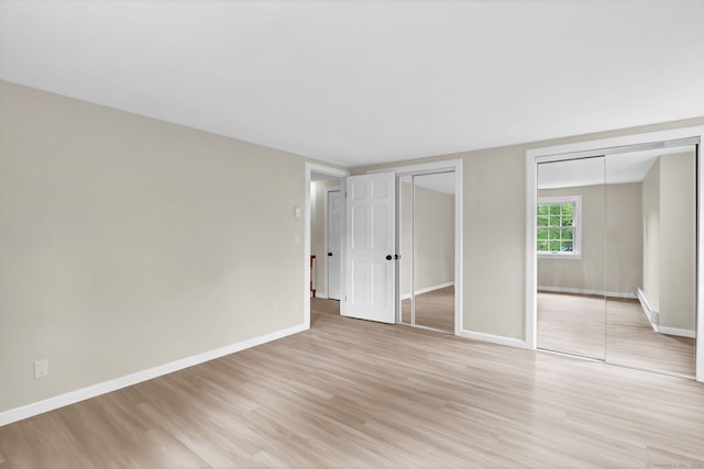 890 Copper Hill Rd, Suffield, CT 06093 - unfurnished bedroom featuring light wood-style flooring and two closets
