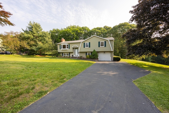10 Longview Ln, Wallingford, CT 06492 - raised ranch featuring a chimney, a garage, driveway, and a front yard