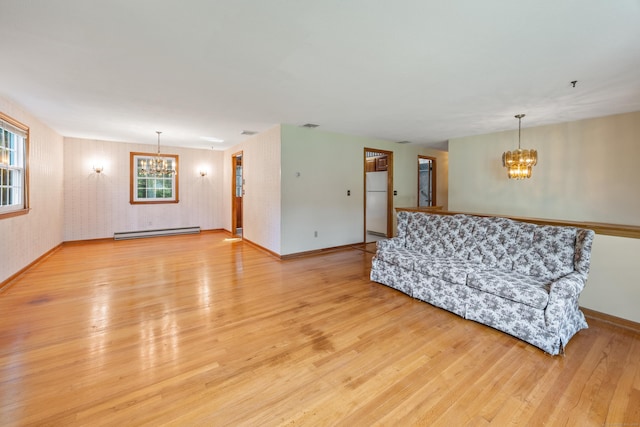 10 Longview Ln, Wallingford, CT 06492 - unfurnished living room featuring a chandelier, a baseboard heating unit, light wood-type flooring, and baseboards