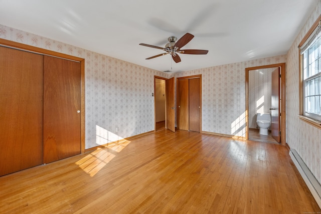 10 Longview Ln, Wallingford, CT 06492 - unfurnished bedroom with baseboard heating, wallpapered walls, light wood-type flooring, multiple closets, and ensuite bathroom
