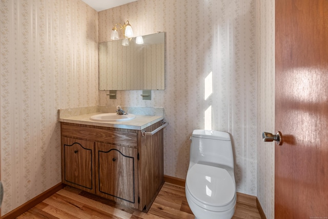 10 Longview Ln, Wallingford, CT 06492 - half bath with wallpapered walls, vanity, wood finished floors, toilet, and baseboards