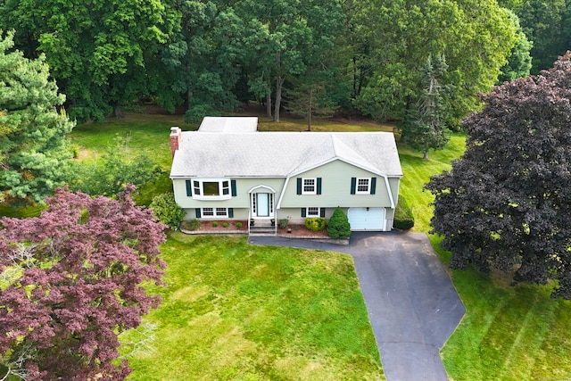 10 Longview Ln, Wallingford, CT 06492 - view of front facade with a chimney, asphalt driveway, an attached garage, and a front yard