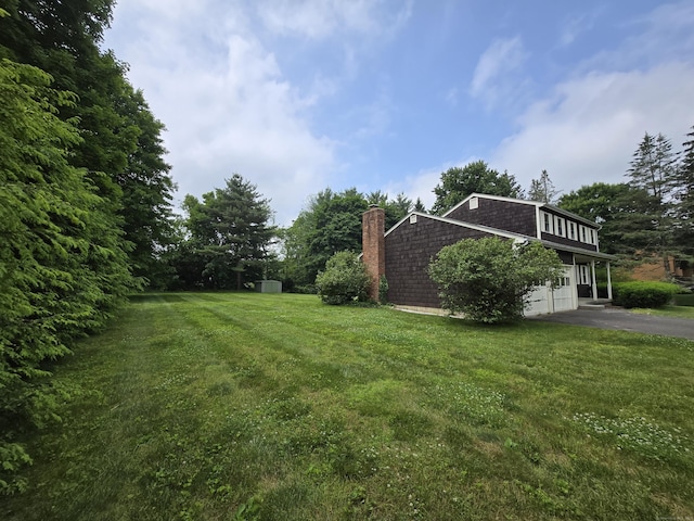 7 Michael Rd, Simsbury, CT 06070 - view of green lawn with asphalt driveway and a garage