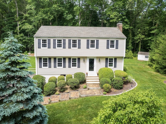 10 Old Kings Hwy, Wilton, CT 06897 - colonial house featuring a chimney, a front yard, a shingled roof, and an outbuilding