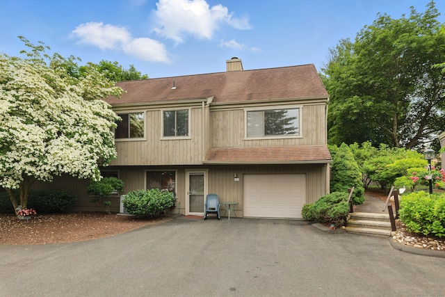 646 Onondaga Ln Unit B, Stratford, CT 06614 - view of front facade with a chimney, an attached garage, asphalt driveway, and a shingled roof
