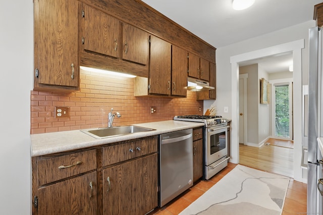 646 Onondaga Ln Unit B, Stratford, CT 06614 - kitchen featuring appliances with stainless steel finishes, under cabinet range hood, a sink, light countertops, and backsplash