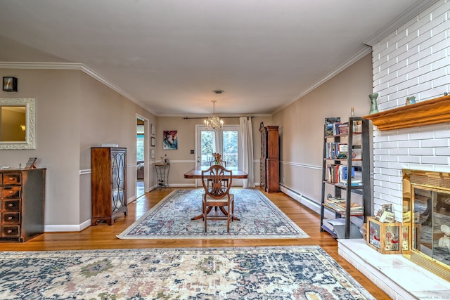 17 Farmstead Ln, West Hartford, CT 06117 - dining room with wood finished floors, a chandelier, ornamental molding, a fireplace, and a baseboard heating unit