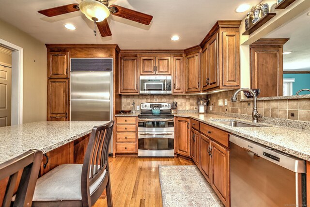17 Farmstead Ln, West Hartford, CT 06117 - kitchen featuring stainless steel appliances, a sink, a ceiling fan, light stone countertops, and tasteful backsplash
