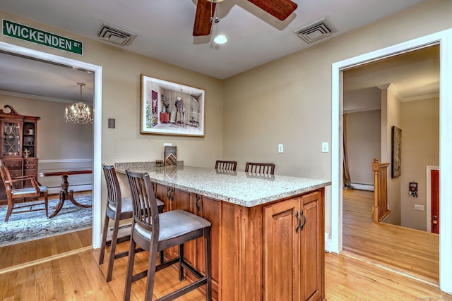 17 Farmstead Ln, West Hartford, CT 06117 - kitchen with ceiling fan, light wood-type flooring, a kitchen bar, light stone counters, and a baseboard radiator