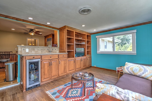 17 Farmstead Ln, West Hartford, CT 06117 - living area with wine cooler, wood finished floors, crown molding, a ceiling fan, and recessed lighting