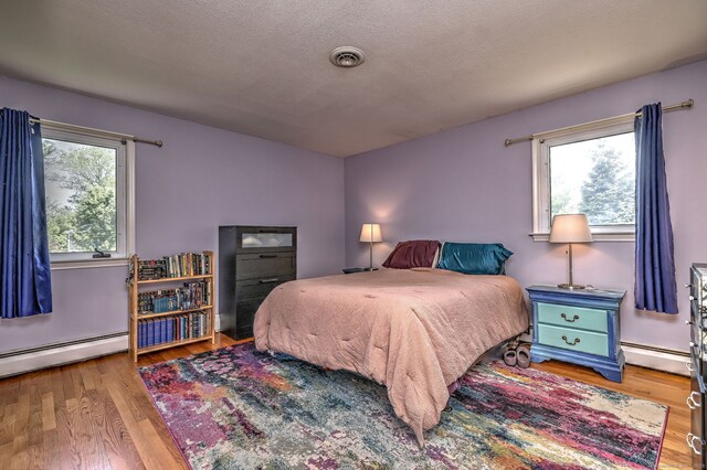 17 Farmstead Ln, West Hartford, CT 06117 - bedroom with a baseboard radiator and wood finished floors