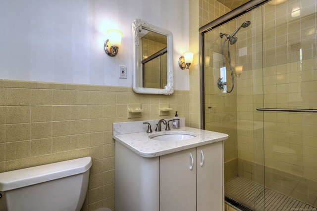 17 Farmstead Ln, West Hartford, CT 06117 - bathroom featuring toilet, tile walls, a shower stall, vanity, and a wainscoted wall
