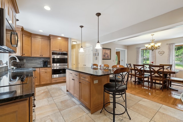 43 Debi Cir, Colchester, CT 06415 - kitchen featuring a kitchen bar, appliances with stainless steel finishes, backsplash, a kitchen island, and a sink