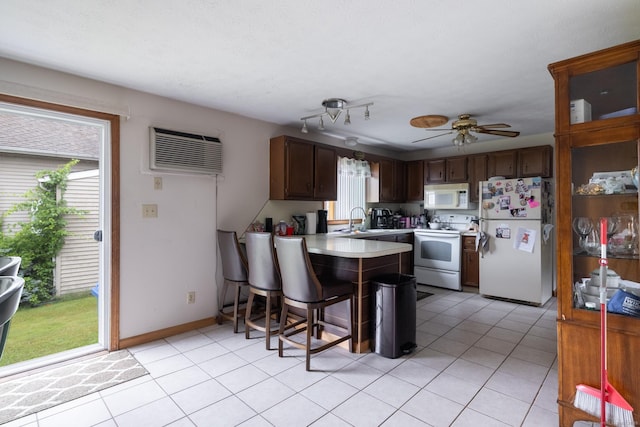 39 Mechanic St, Bristol, CT 06010 - kitchen featuring white appliances, a peninsula, an AC wall unit, light countertops, and plenty of natural light