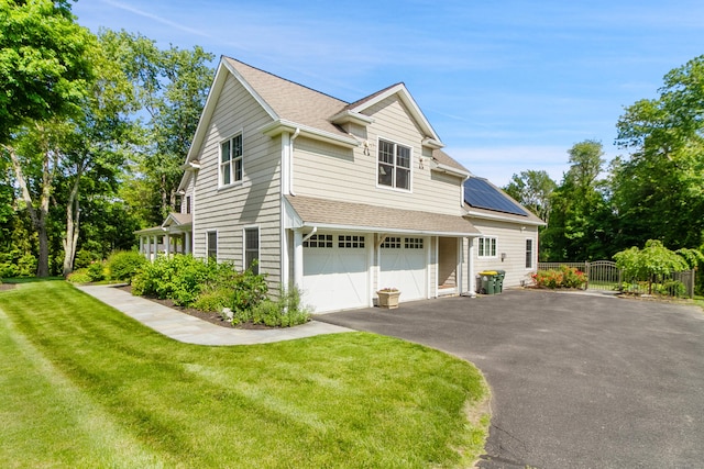 11 Delno Dr, Danbury, CT 06811 - view of front facade featuring driveway, roof mounted solar panels, a garage, and a shingled roof