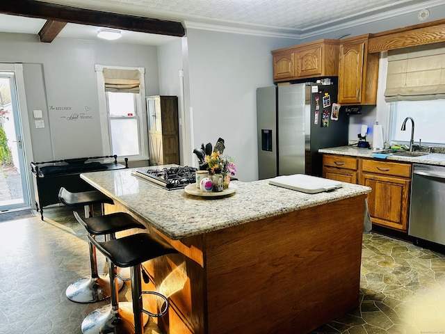 92 Curtiss St, Naugatuck, CT 06770 - kitchen featuring stainless steel appliances, a sink, brown cabinets, light stone counters, and a center island