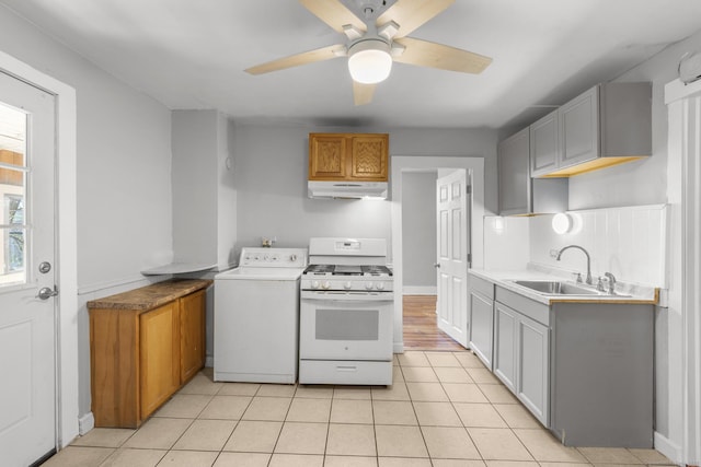 480 W St, Bristol, CT 06010 - kitchen with white gas range, under cabinet range hood, washer / clothes dryer, ceiling fan, and light tile patterned flooring