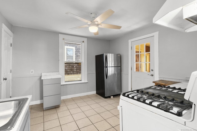 480 W St, Bristol, CT 06010 - kitchen featuring freestanding refrigerator, white range with gas stovetop, light tile patterned flooring, ceiling fan, and range hood