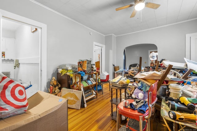 480 W St, Bristol, CT 06010 - living room featuring wood finished floors, ceiling fan, ornamental molding, arched walkways, and radiator heating unit