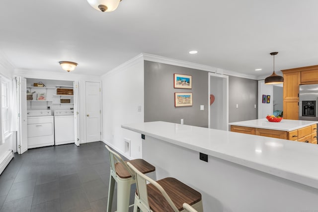 19 W Hills Rd, Essex, CT 06442 - kitchen with stainless steel fridge, washing machine and clothes dryer, light countertops, ornamental molding, and a breakfast bar