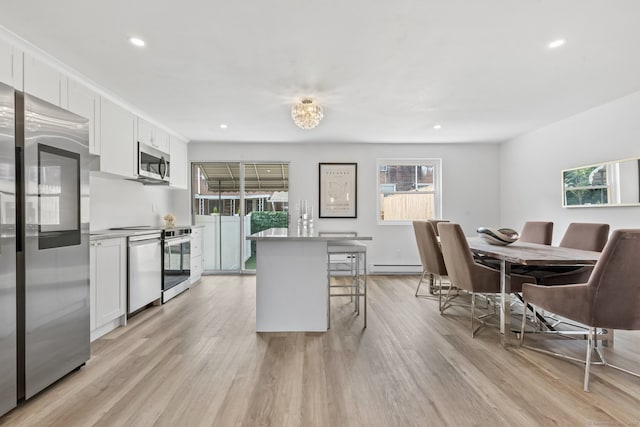 17 Avon Ln, Stamford, CT 06907 - kitchen with stainless steel appliances, plenty of natural light, a kitchen bar, recessed lighting, and white cabinetry