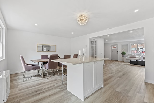 17 Avon Ln, Stamford, CT 06907 - kitchen with a breakfast bar area, recessed lighting, light wood-style floors, white cabinetry, and a kitchen island