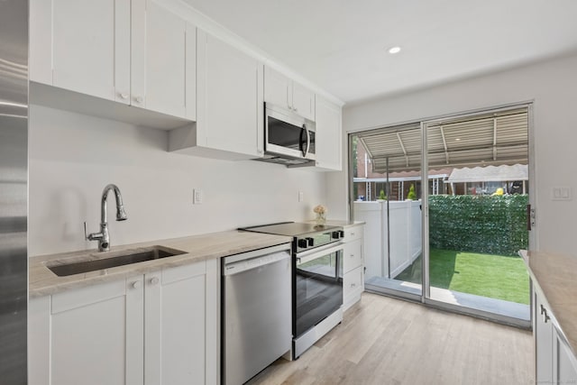 17 Avon Ln, Stamford, CT 06907 - kitchen featuring stainless steel appliances, a sink, white cabinetry, light wood-style flooring, and recessed lighting