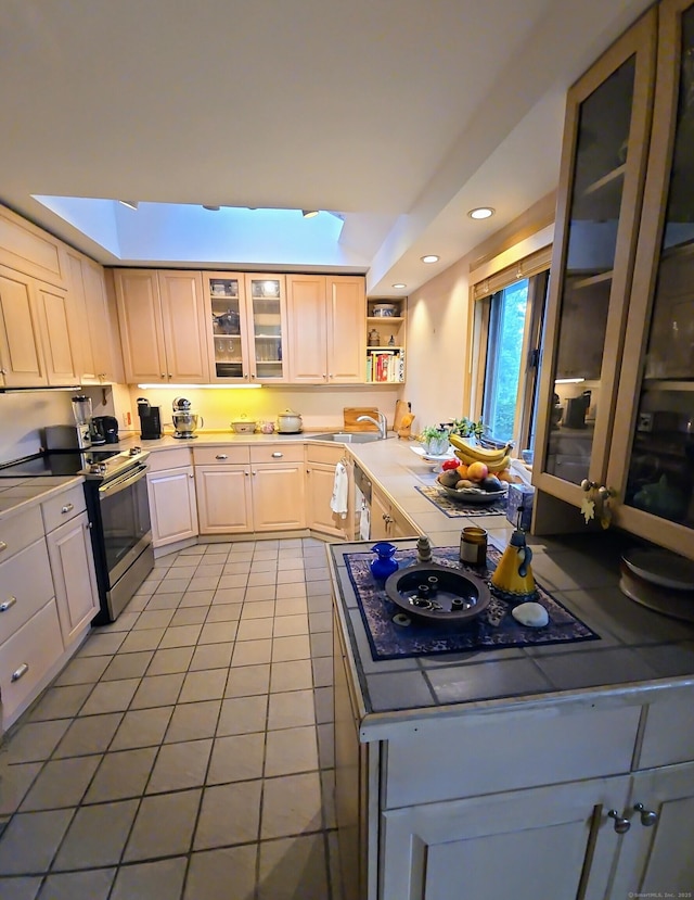 44 Wilbur Rd, Washington, CT 06777 - kitchen with stainless steel electric stove, black electric stovetop, light tile patterned flooring, glass insert cabinets, and light countertops