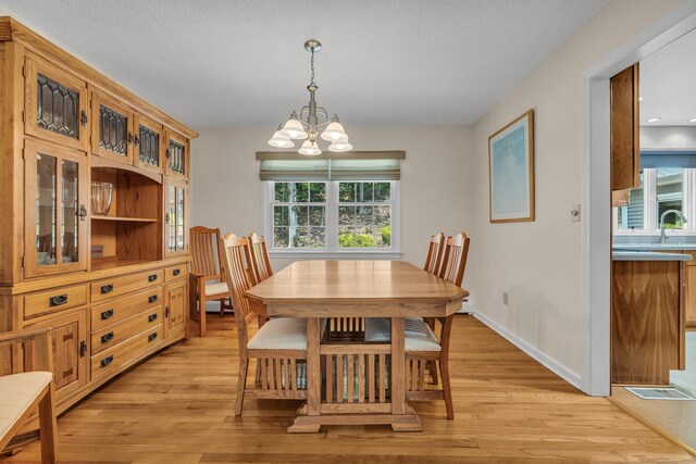 35 Whitethorn Dr, Guilford, CT 06437 - dining area with light wood-type flooring, plenty of natural light, a chandelier, a textured ceiling, and baseboards