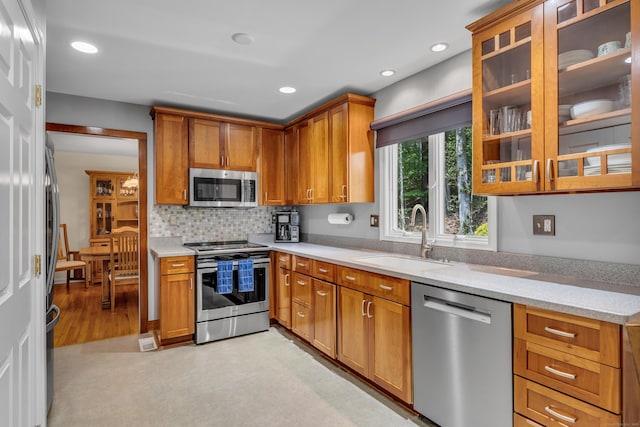 35 Whitethorn Dr, Guilford, CT 06437 - kitchen featuring appliances with stainless steel finishes, a sink, brown cabinets, decorative backsplash, and recessed lighting