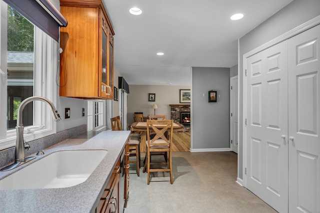35 Whitethorn Dr, Guilford, CT 06437 - kitchen with a sink, brown cabinetry, glass insert cabinets, recessed lighting, and baseboards